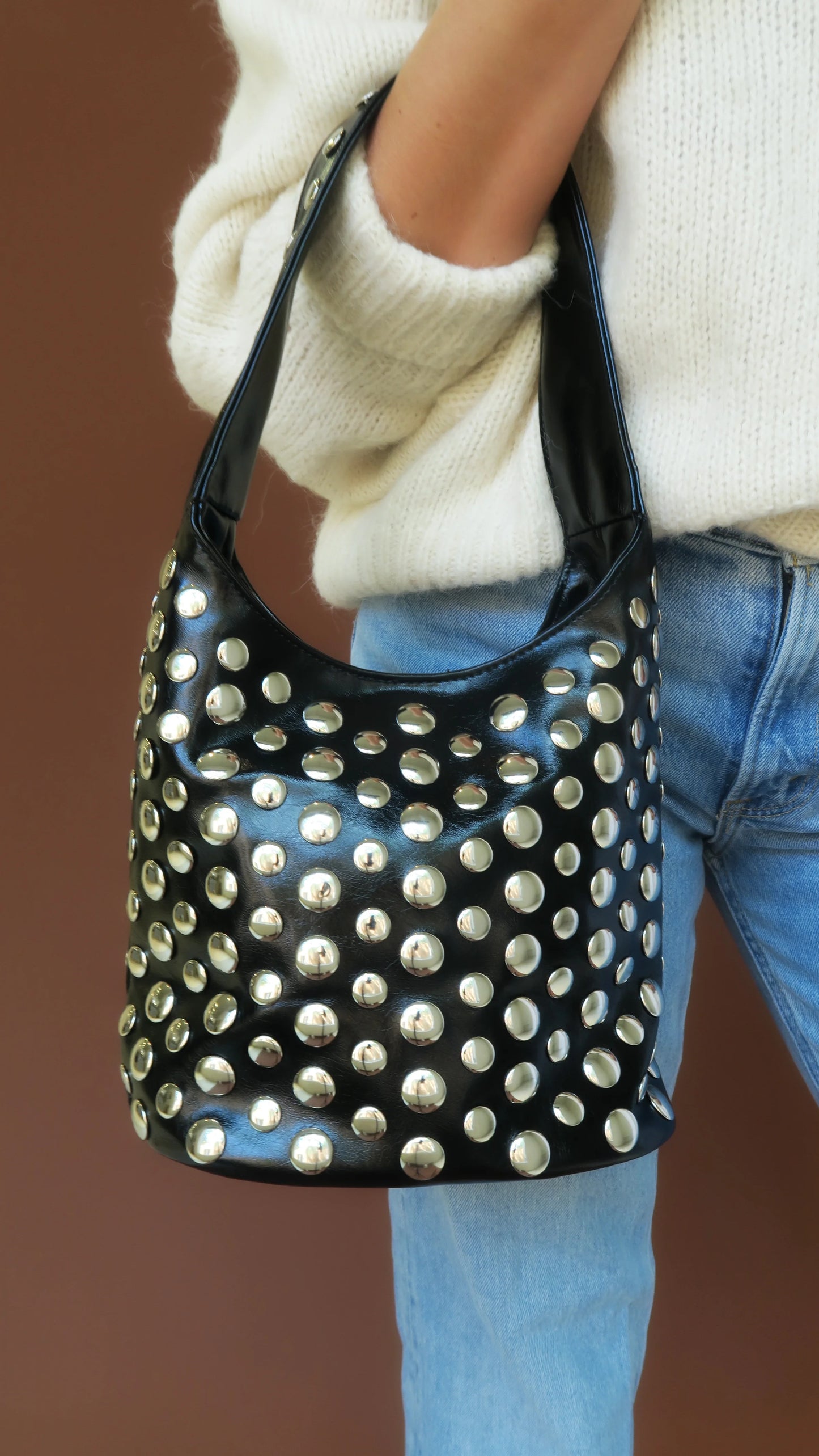 Schwarze Studded Bag mit silbernen Nieten, an den Henkeln getragen