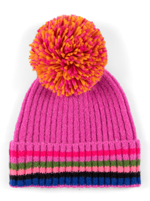 Ronen Hat Magenta with a vibrant pink knit body, multicolored striped cuff in blue, pink, red, and green, topped with a large orange and pink pom-pom, offering a playful Hill Country style.