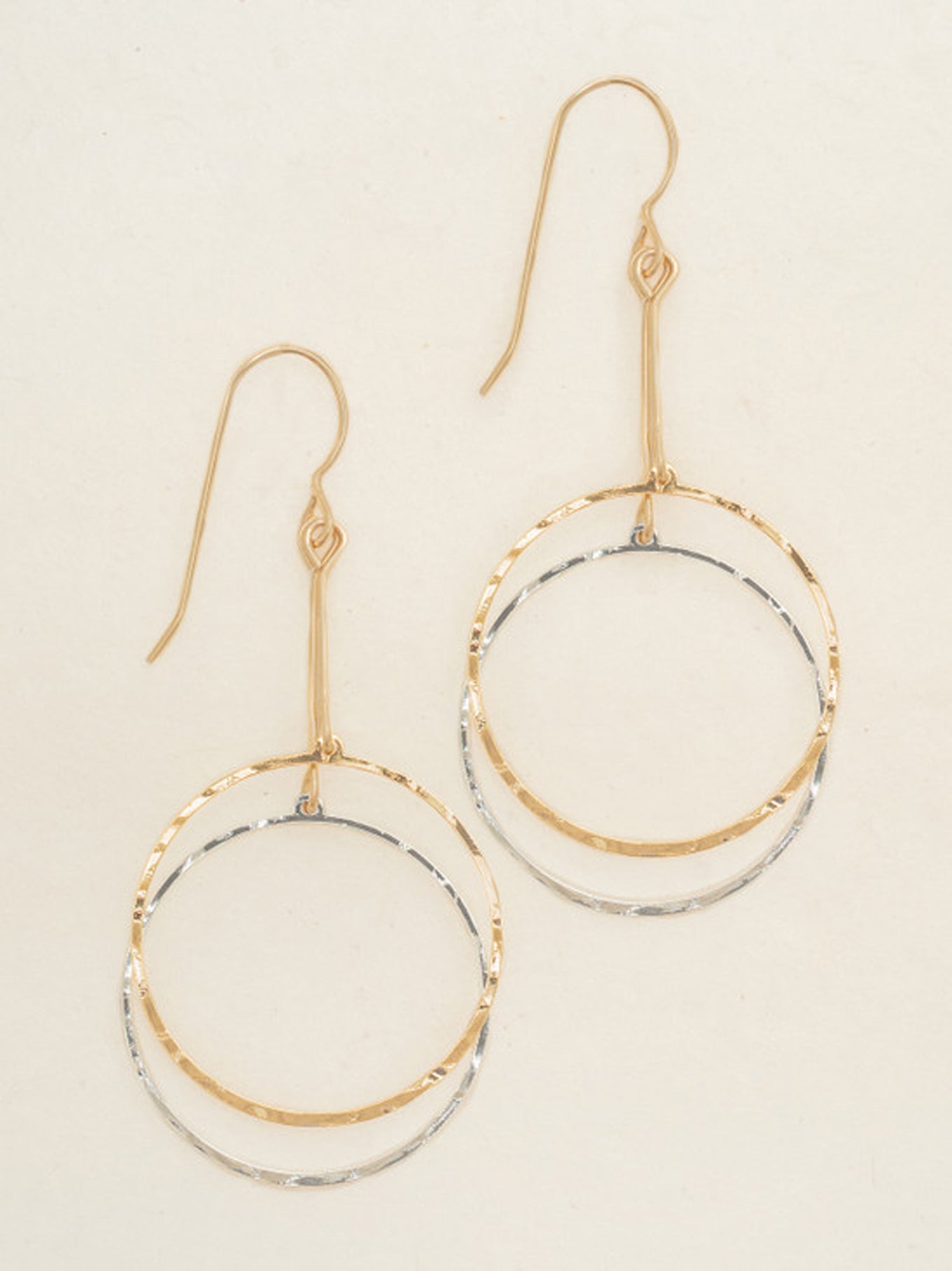 Dancing Circles Earring Gld/Slv featuring intertwined hammered gold and silver rings hanging from elegant gold hooks, showcasing artisan-made effortless Hill Country style.