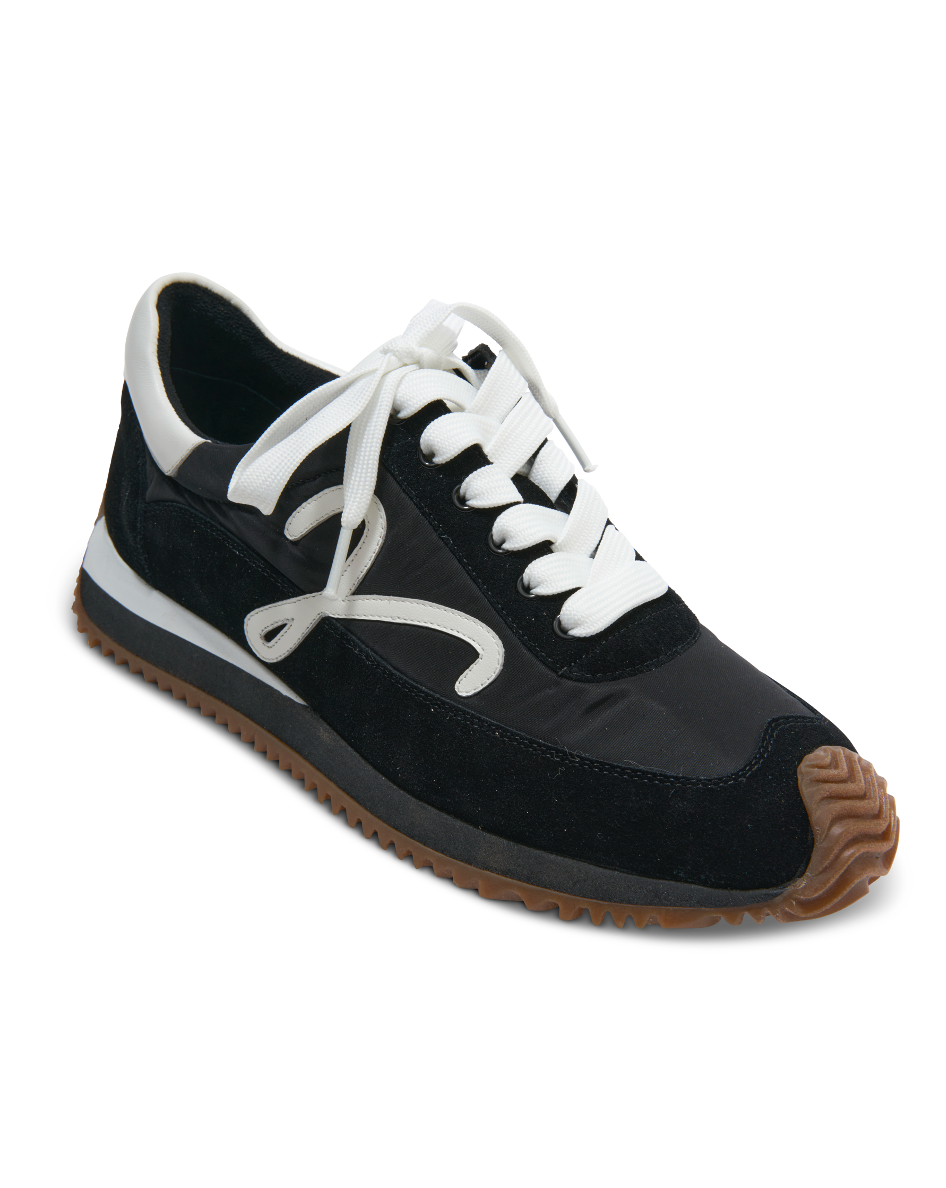 Schwarzer Sneaker mit weißen Schnürsenkeln, seitlichen Overlays und braunem Sohlenprofil
