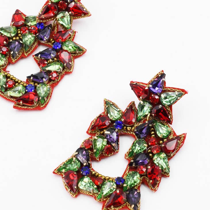 Close-up of Red Jeweled Wreath Earring featuring teardrop-shaped red, green, and purple stones set in gold-tone metal, showcasing a festive and vibrant design.