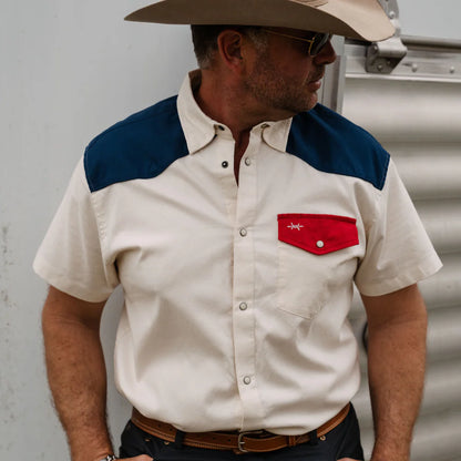 White pearl snap short-sleeve shirt with blue shoulder yoke and red snap chest pocket