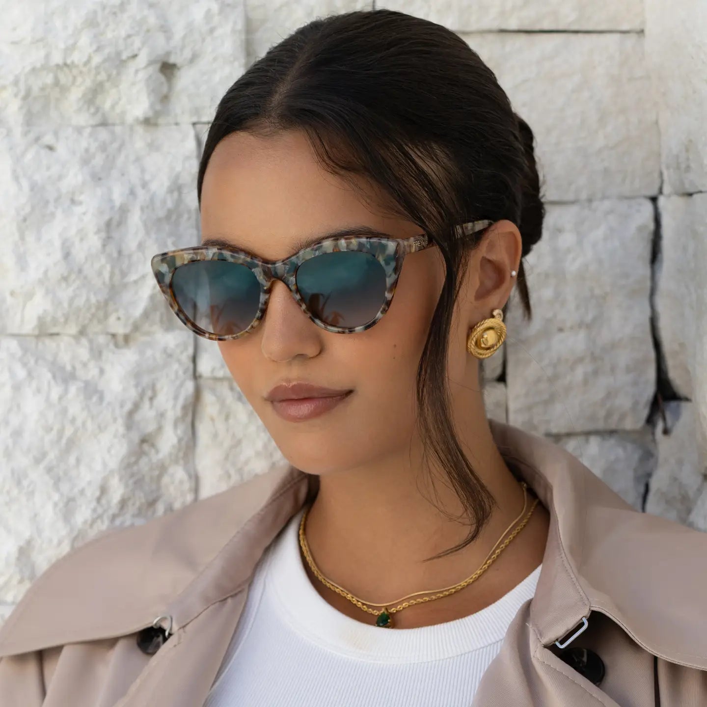 Brown tortoiseshell cat-eye sunglasses with gray lenses, worn on face
