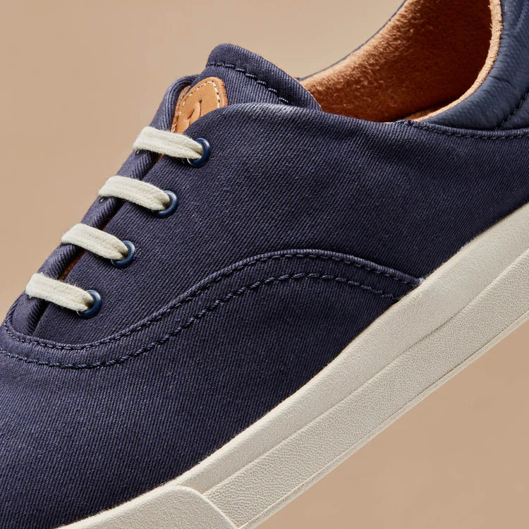 Navy canvas upper close-up with white laces and tan leather lace tag