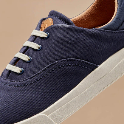 Navy canvas upper close-up with white laces and tan leather lace tag