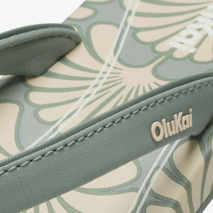 Close-up of green Uiki W strap logo on leaf-printed footbed