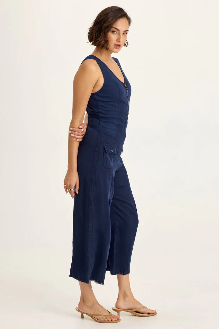 Linette Jumpsuit in navy Taissa Twill with brass zipper, flap pockets, and pleated cropped wide leg