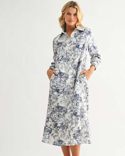 Janett Dress with blue floral toile print, collared neckline, long sleeves, and button front