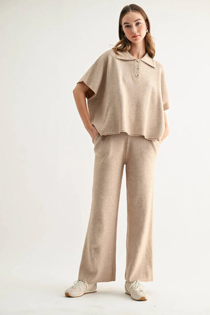 Woman wearing a beige collared knit top and wide-leg pants with sneakers