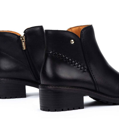 Botines negros con cremallera interior y detalle de botón metálico