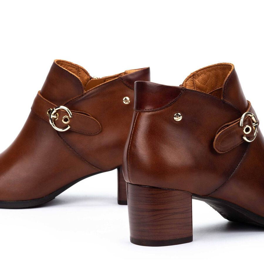 Botines cuero con hebilla circular metálica y paneles laterales