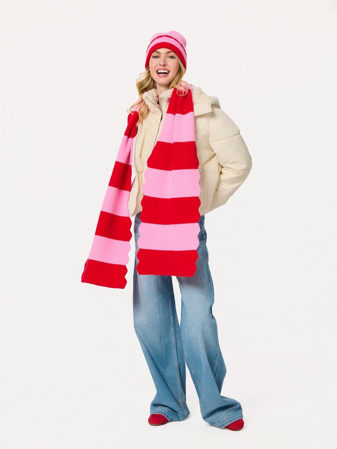 Woman wearing Scala Striped Scarf in vibrant red and pink with knit hat at HCO Fredericksburg TX