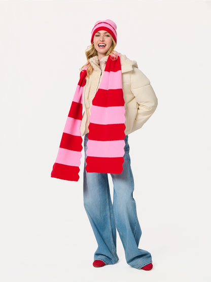 Woman wearing Scala Striped Scarf in vibrant red and pink with knit hat at HCO Fredericksburg TX