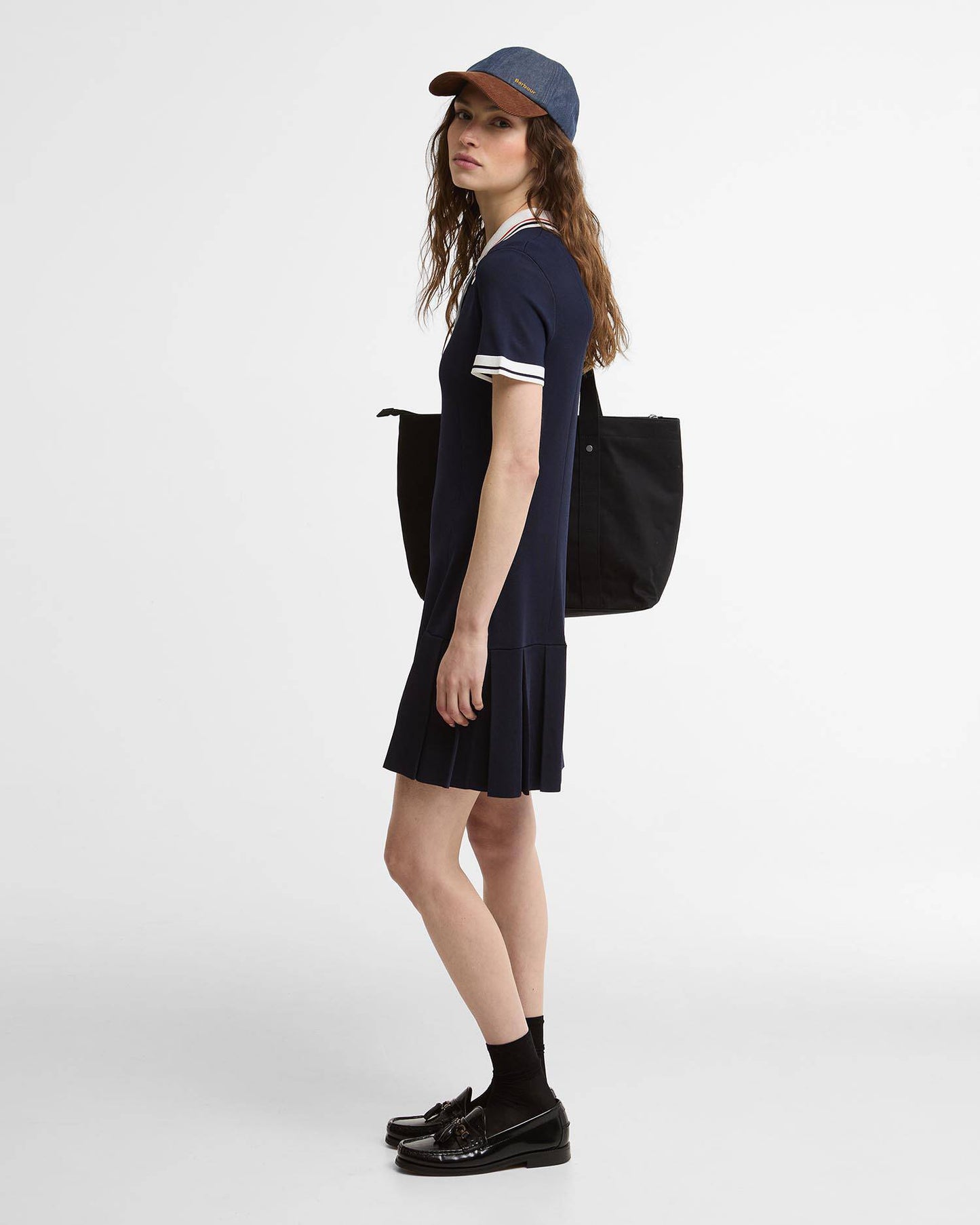 Hollington Knitted Mini Dress in navy with white trim styled with casual hat and tote bag by BARBOUR INC.