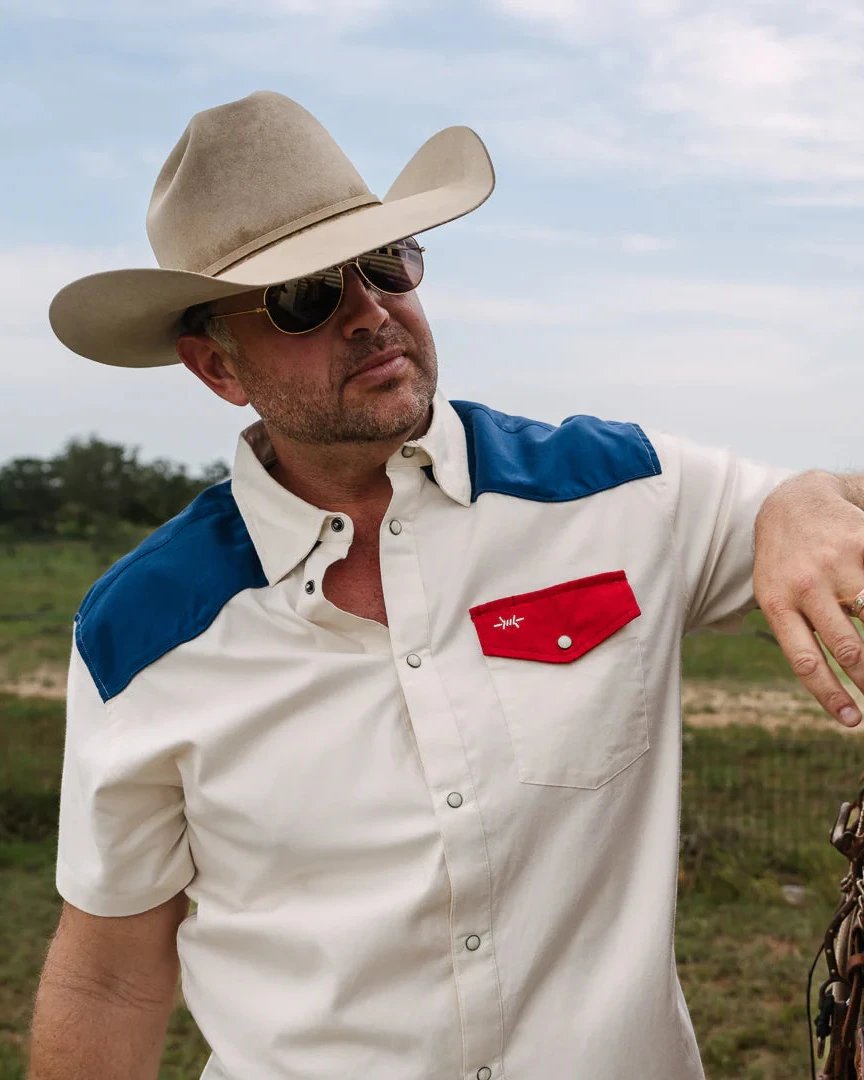 White short-sleeve pearl snap western shirt with blue yoke and red chest pocket