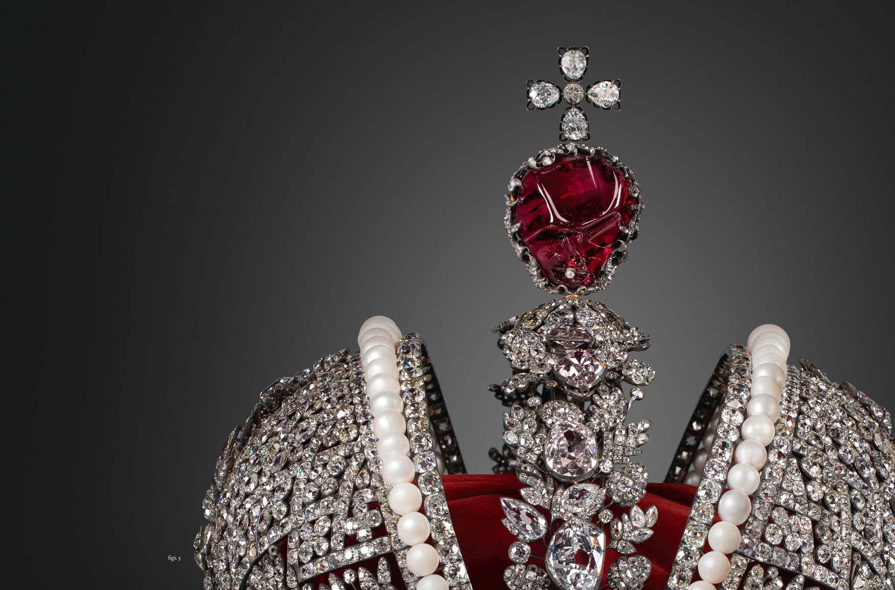 Close-up of an ornate jeweled crown featuring large red gemstones, pearls, and clear sparkling diamonds, showcasing craftsmanship in Diamonds Across Time: Facets Of Mankind.