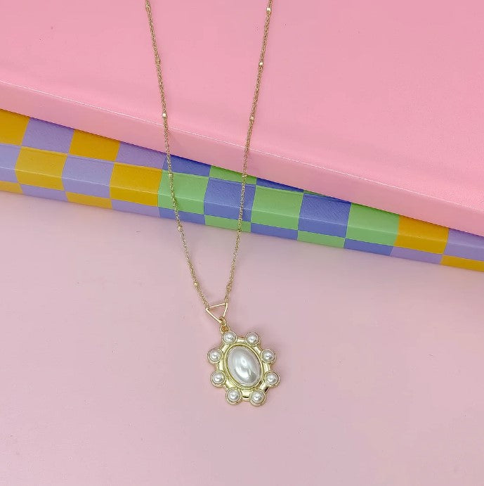 Gold pearl pendant necklace with oval centerpiece and small round pearls