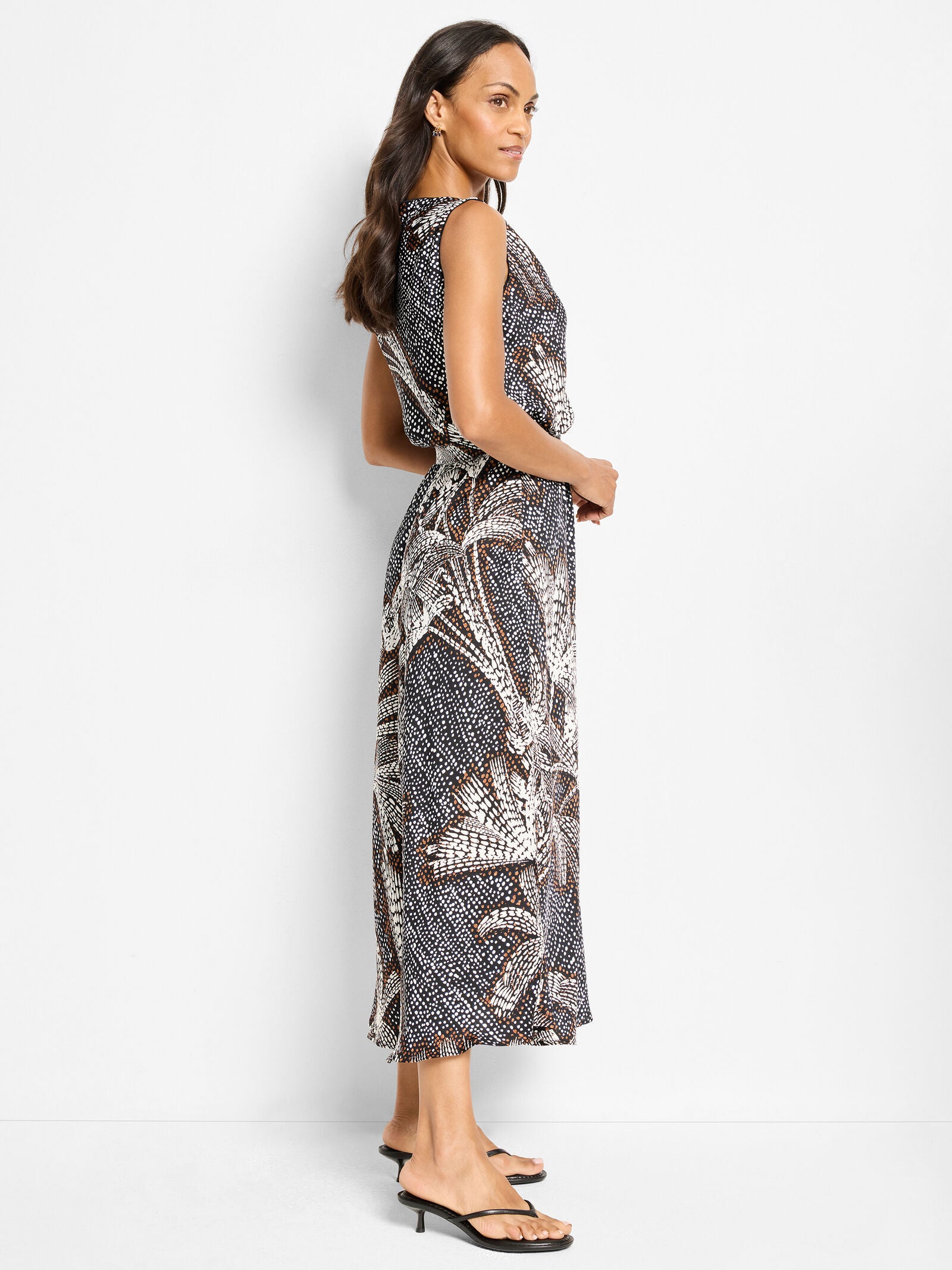 Black multi sleeveless midi dress, boat neckline, side profile with palm dot pattern