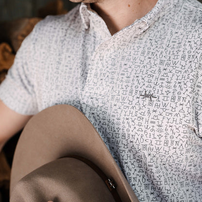 Ash polo on model, short sleeves with repeating logo print