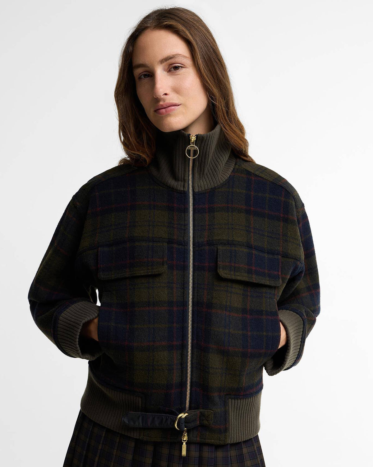 Woman wearing a dark plaid zip-up jacket with a ribbed collar and cuffs