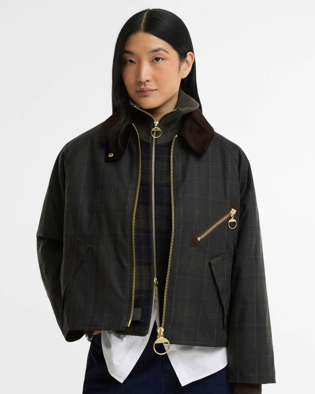 Woman wearing a black plaid jacket with gold zippers and a burgundy collar
