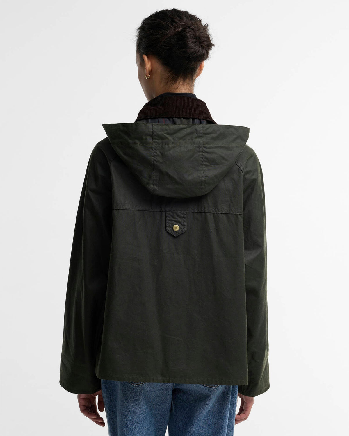 Person seen from behind wearing a dark green hooded jacket and blue jeans