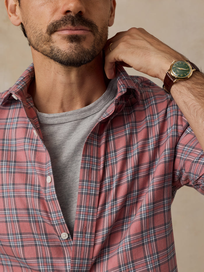 Man wearing a red plaid shirt over a gray T-shirt and wristwatch