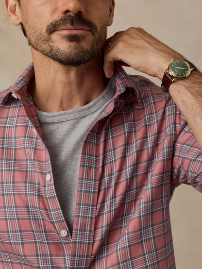 Man wearing a red plaid shirt over a gray T-shirt and wristwatch