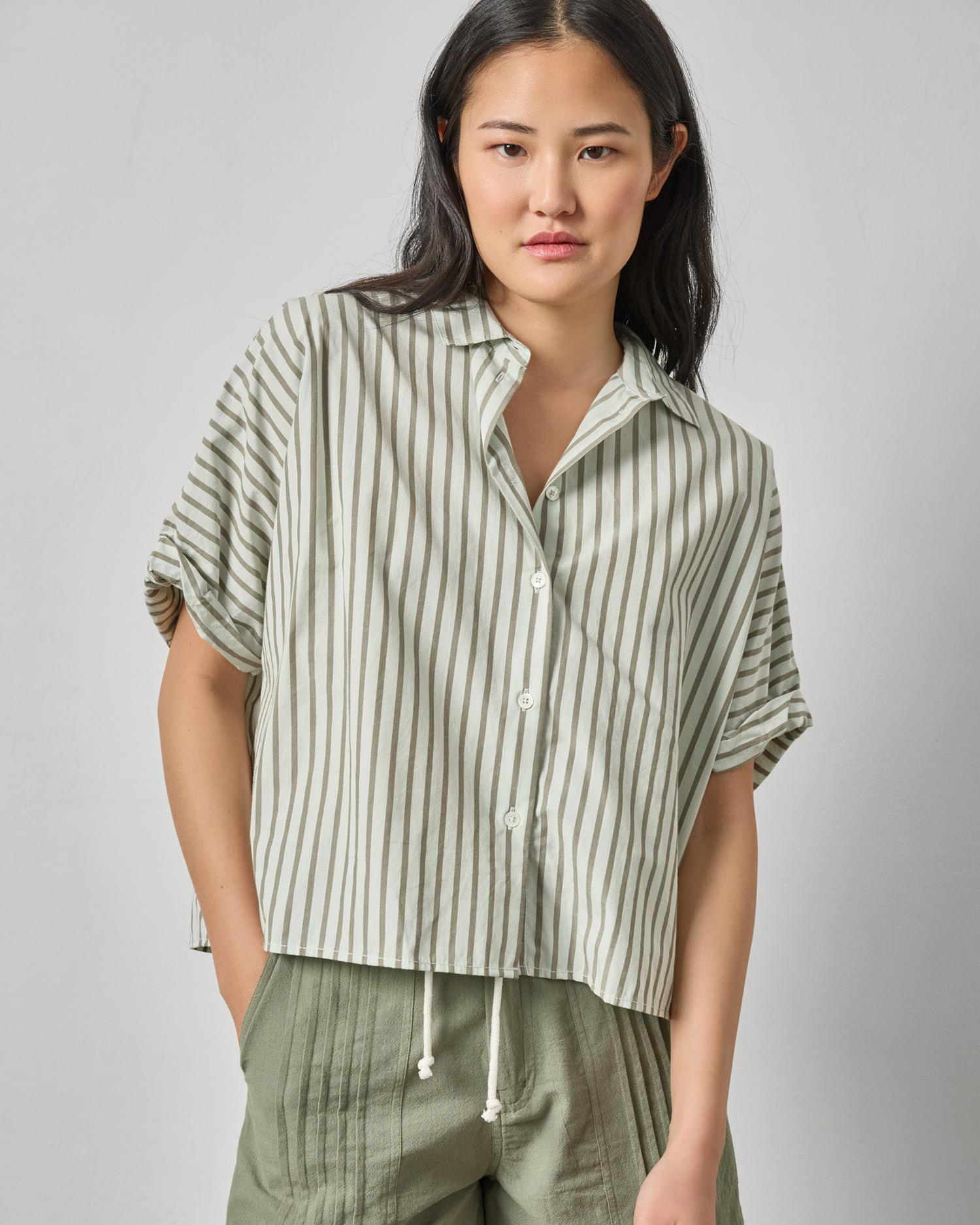 Model wearing Striped Oversized Button Down Dolman in cotton poplin, styled with casual green shorts