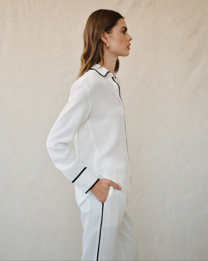 Off-white button-up shirt with contrast black piping at collar and down sleeves