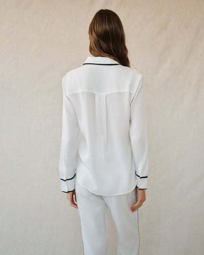 Back view of off-white shirt with contrast black collar band and button-cuff trim