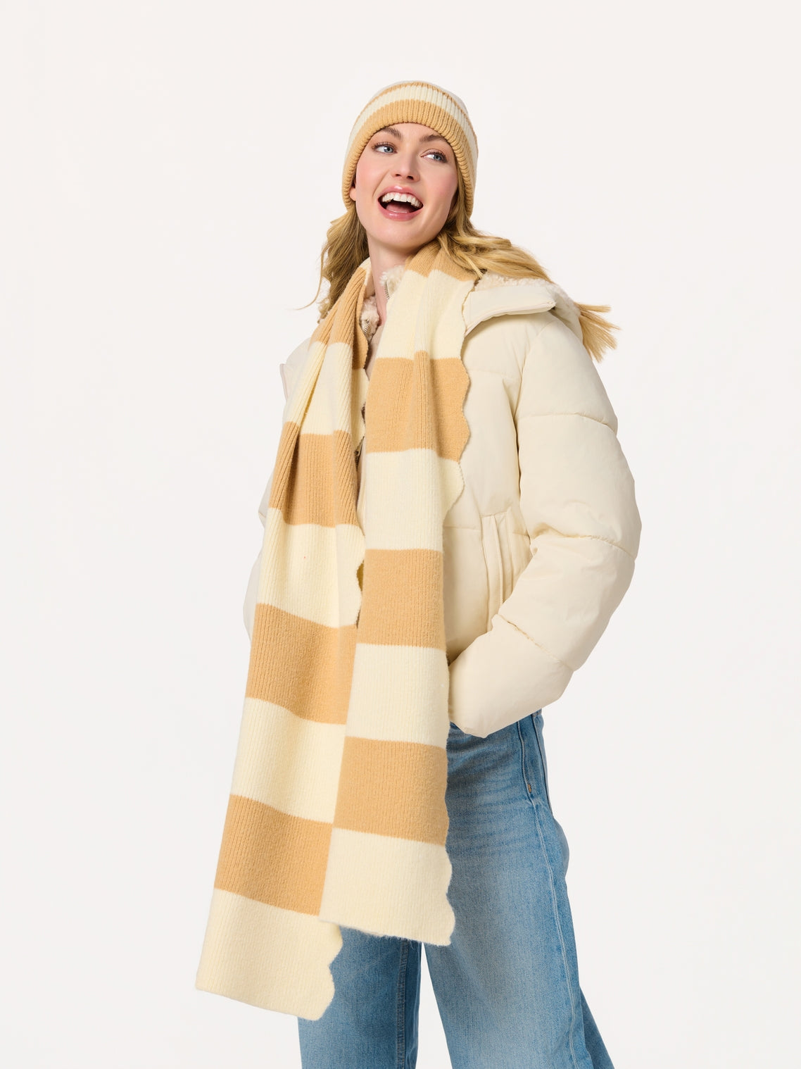 Woman wearing Scala Striped Scarf in cream and tan with knit hat and cream jacket at HCO FBG
