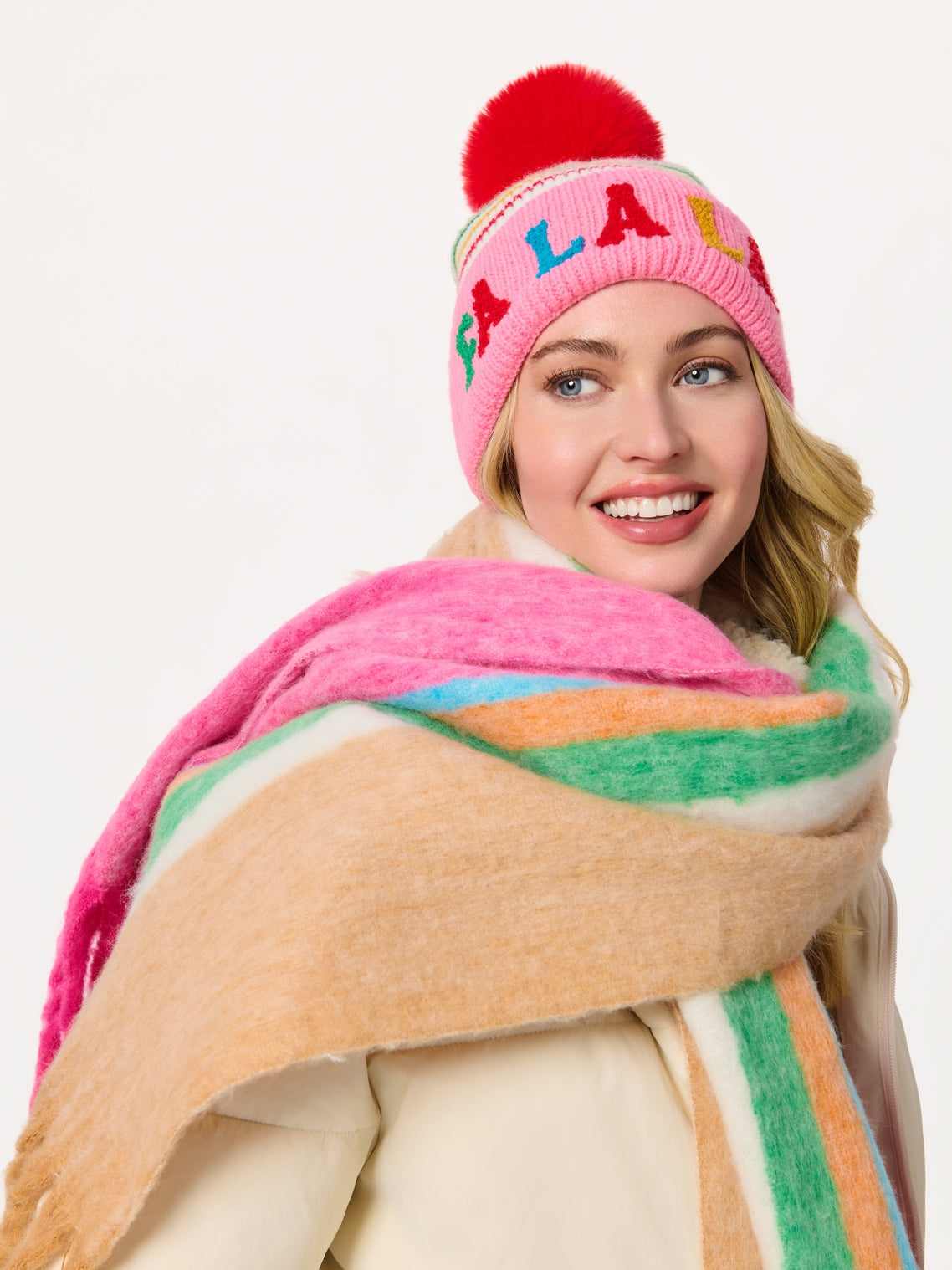 Mina Scarf wrapped with bold pink, green, orange stripes, styled with colorful pom-pom beanie
