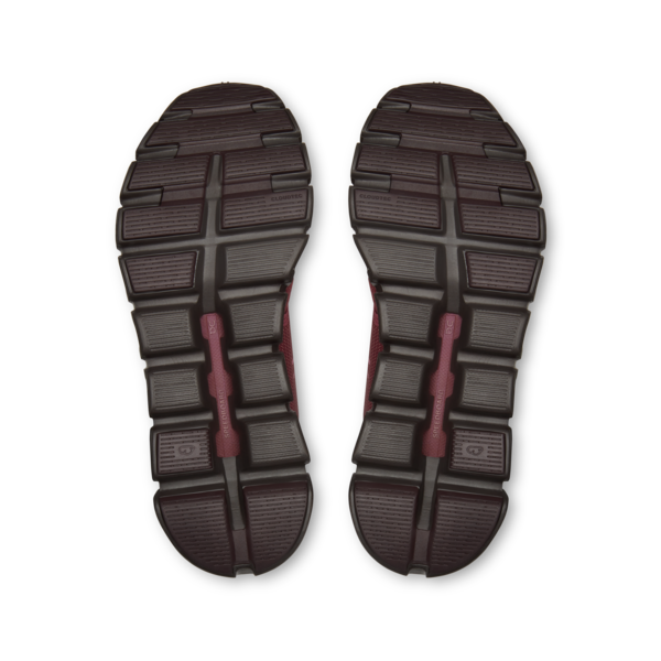 Pair of dark athletic shoe soles on a black background