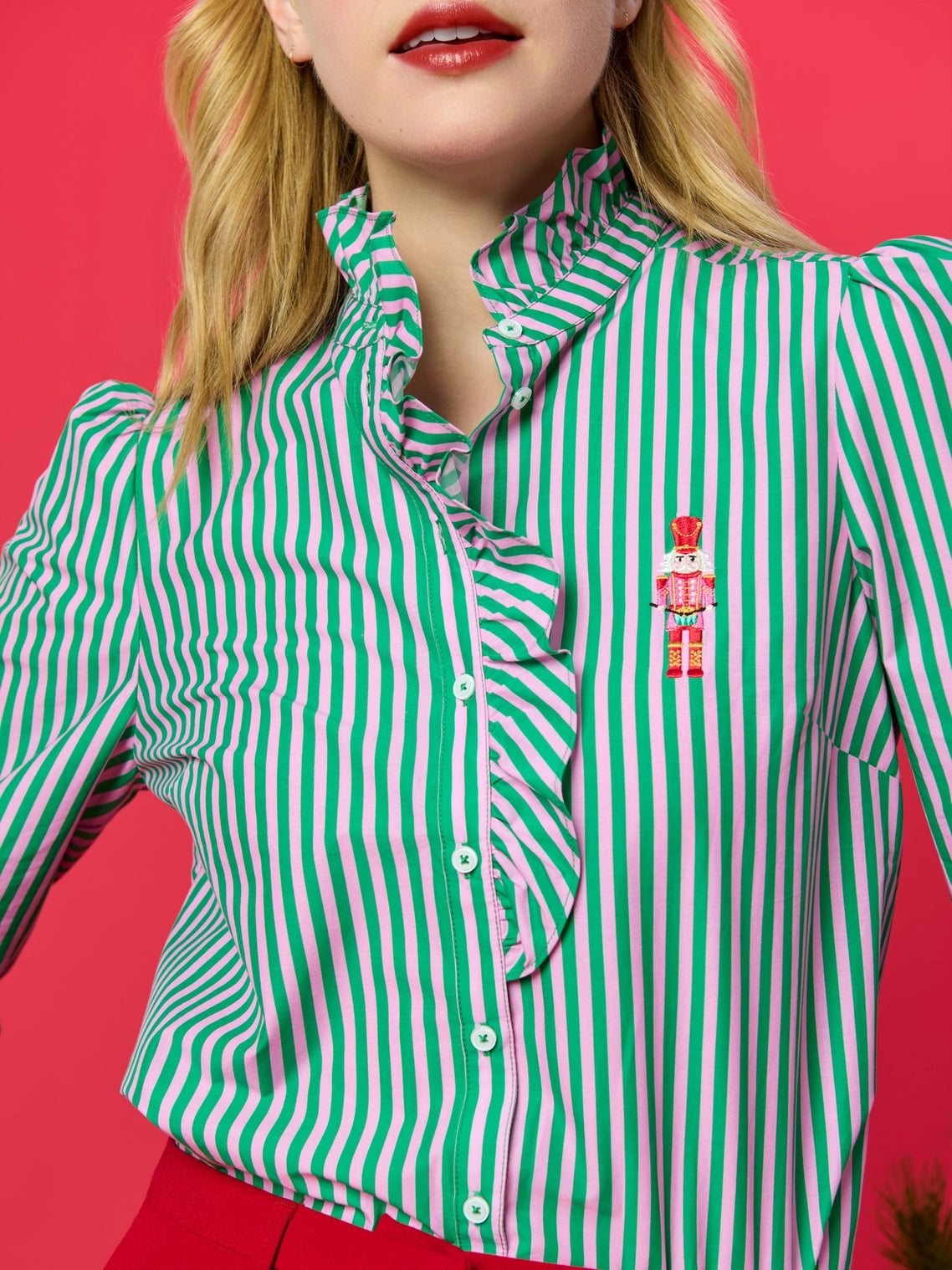 Woman wearing Nutcracker Ruffle Blouse with green and white stripes, styled at HCO Fredericksburg