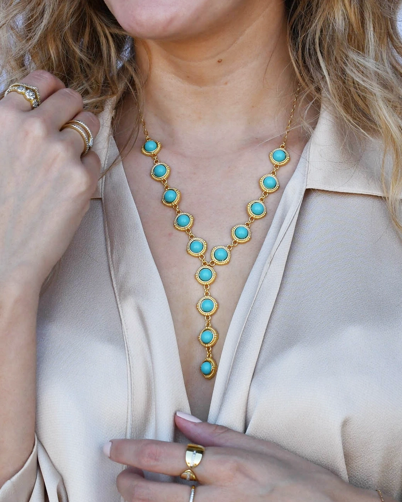 Turquoise Cascade Gold Necklace with radiant turquoise stones and gold setting on model's neck