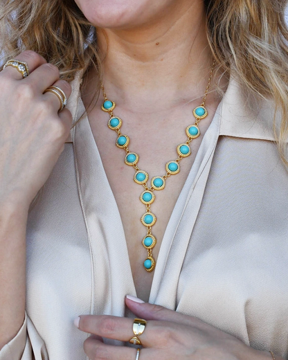 Turquoise Cascade Gold Necklace with radiant turquoise stones and gold setting on model's neck