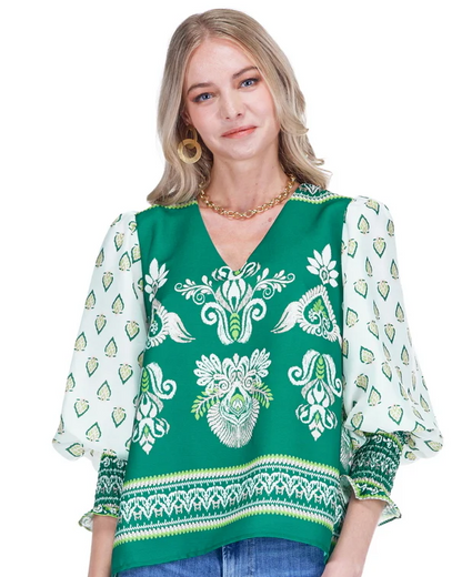 Woman wearing a green patterned blouse with a white background