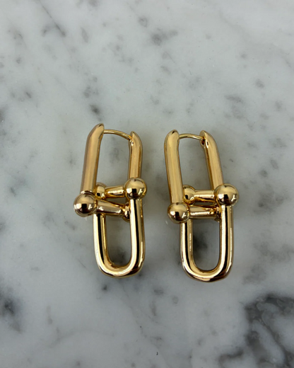 Pair of gold dangle earrings: U-shaped hoops with cross bar and round balls