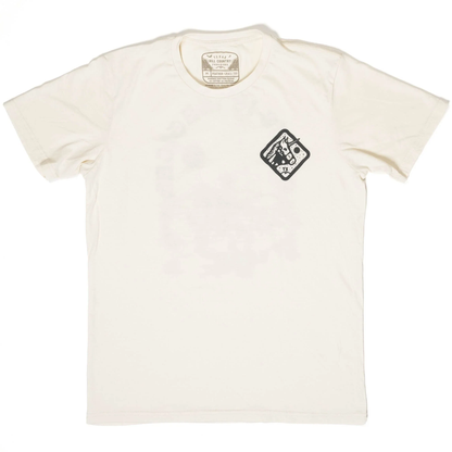 Cream-colored short-sleeve cotton tee with a small black graphic emblem on the chest, featuring the "Texas Is Magical Tee" in a casual, comfortable style.