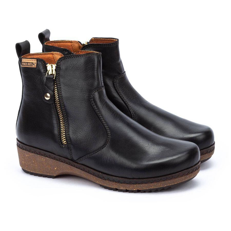 Black leather ankle boots with side zippers and textured wedge soles