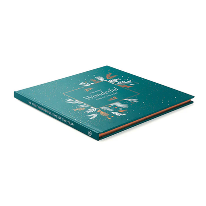 Hardcover book titled The Most Wonderful Time Of The Year with a teal cover adorned with gold and white botanical illustrations, reflecting a premium, personally curated style from Fredericksburg, Texas.