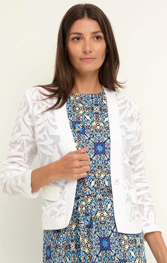Woman wearing Garden Lace Jacket in white floral knit over a blue patterned dress from Nic and Zoe