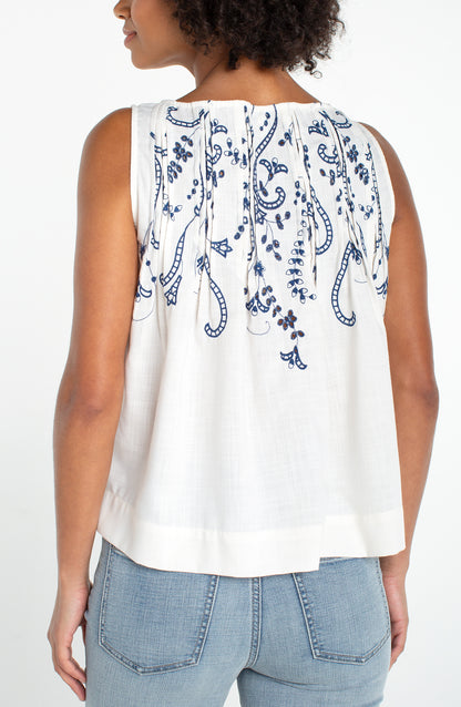 Sleeveless Boat Neck Woven Top W/ Pintucks in white with blue floral embroidery on back