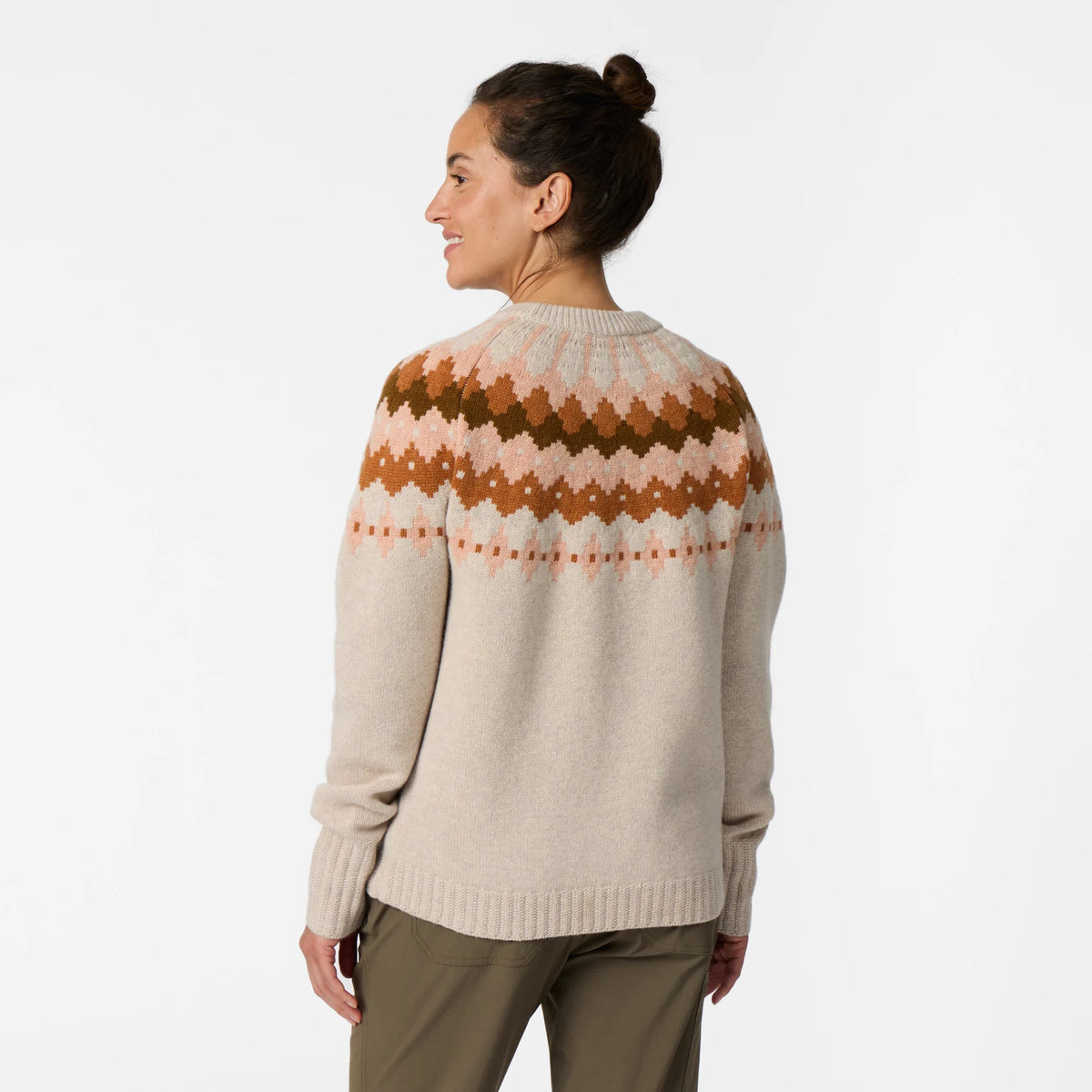 Woman wearing a beige Fair Isle sweater and olive pants against a white background