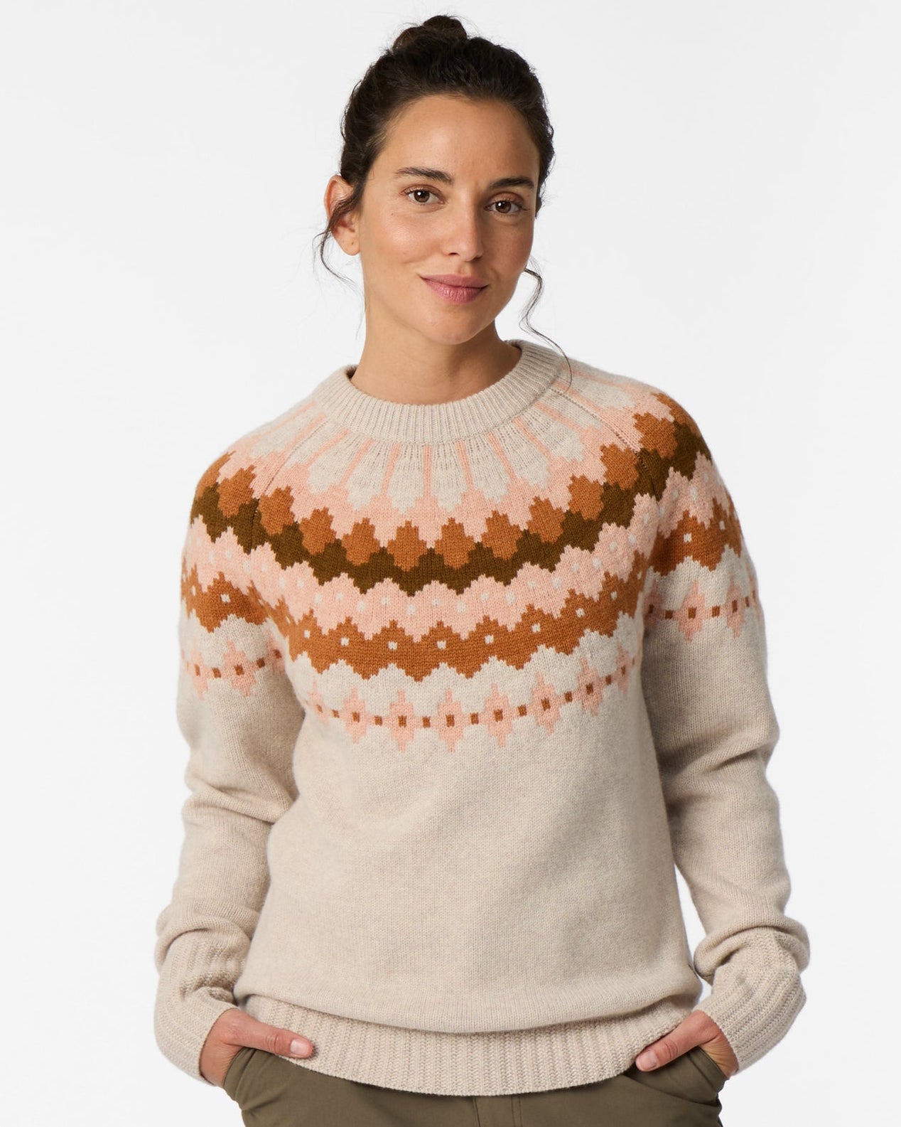 Woman wearing a beige sweater with a brown and rust geometric pattern