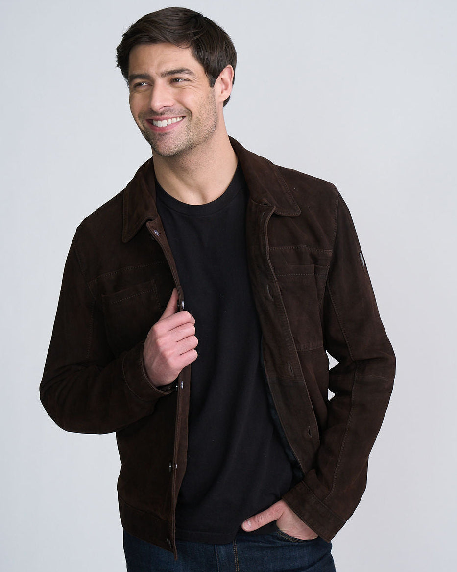 Smiling man wearing a brown jacket over a black shirt